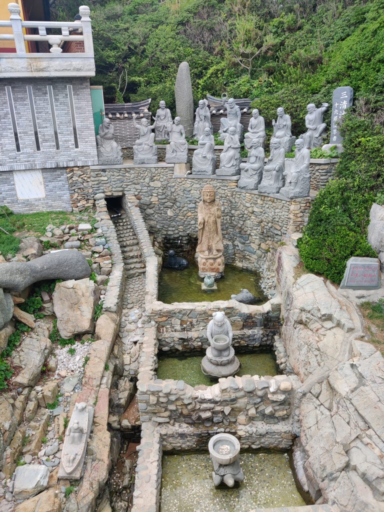 Statue where you throw coins for wishes in a temple